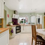 Modern kitchen with dining table and appliances.
