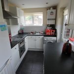 Modern kitchen with white cabinets and appliances.