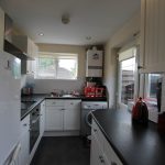 Modern kitchen with appliances and white cabinets.