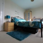 Cosy bedroom with teal decor and stylish furniture.