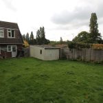 Back garden with shed and house view.