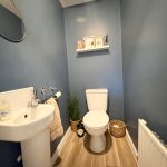 Compact modern bathroom with blue walls and fixtures.