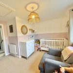 Cosy nursery with crib and chest of drawers.
