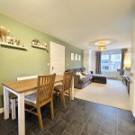 Modern living room and dining area with green wall.
