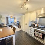 Modern kitchen and living area with dining table.