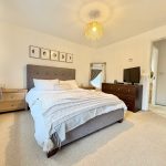 Bright bedroom with modern decor and large bed.