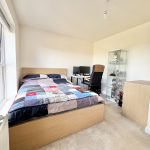 Bedroom with desk and display cabinet.