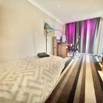 Bedroom with bed, desk, and fireplace