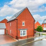 Modern brick houses in a suburban UK street.